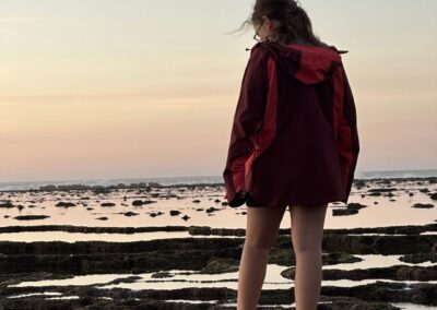 jeune fille sur le bord de l'eau avec coucher de soleil