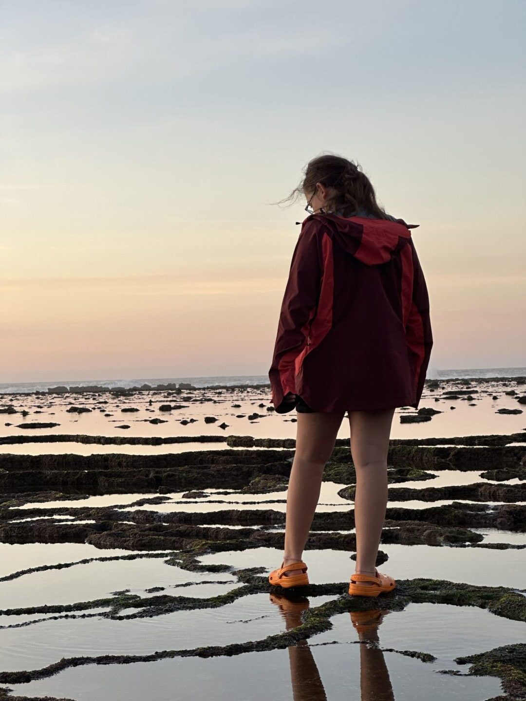 jeune fille sur le bord de l'eau avec coucher de soleil