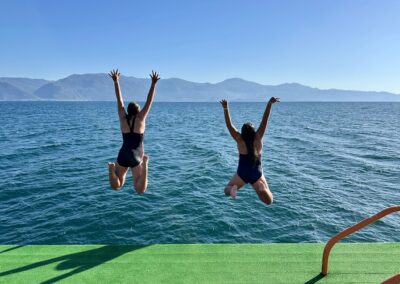deux jeunes filles sautant dans l'eau dans un lac