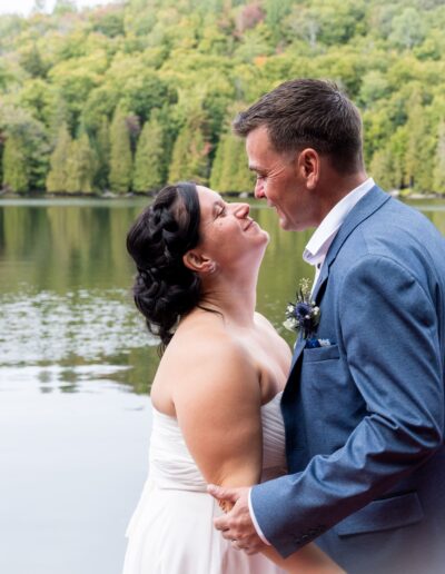couple de mariés se regardant devant un lac