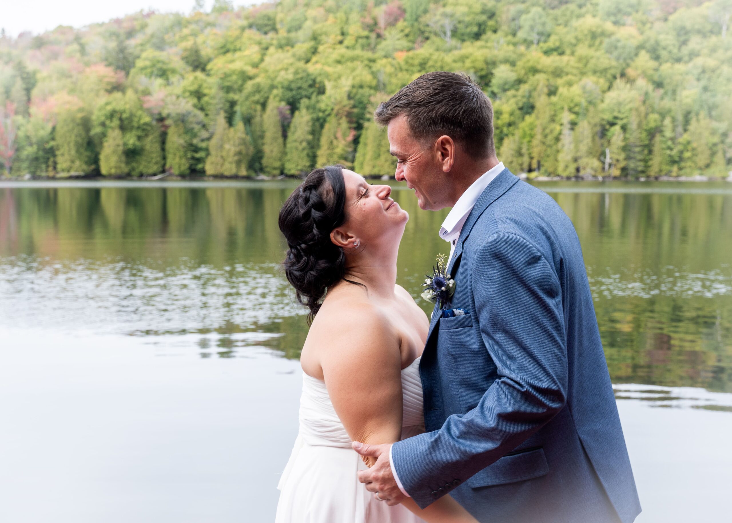 couple de mariés se regardant devant un lac