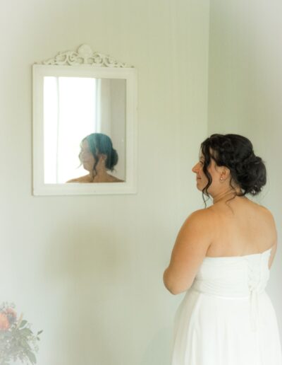 mariée de dos avec reflet du visage dans un miroir