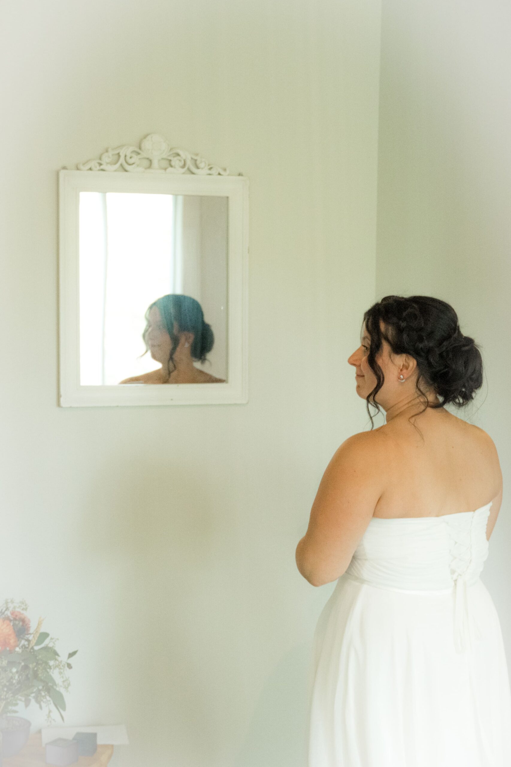 mariée de dos avec reflet du visage dans un miroir