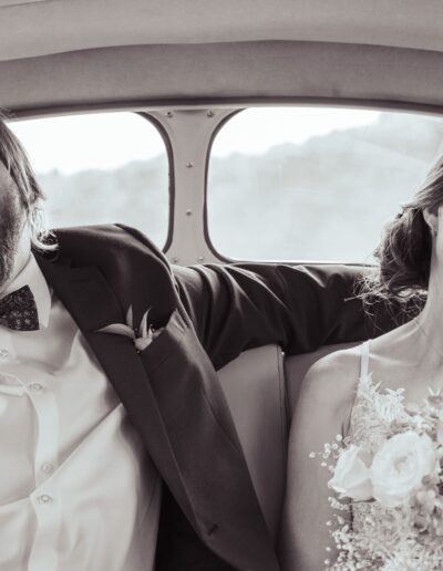 couple marié qui rie dans une voiture