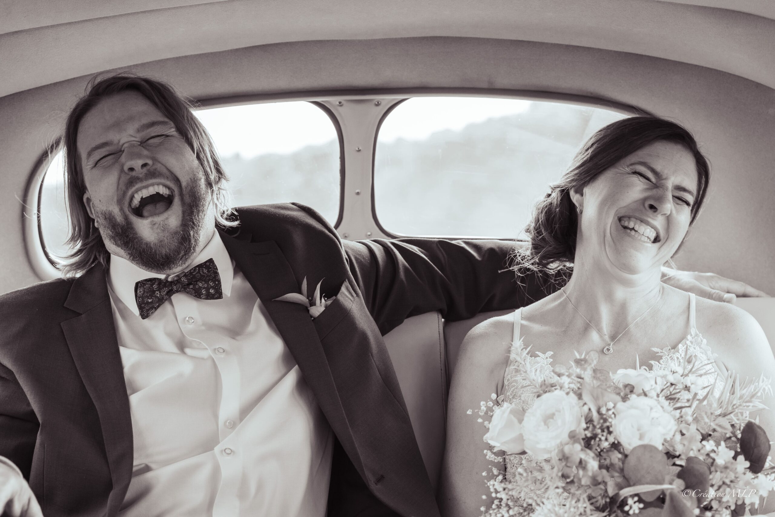 couple marié qui rie dans une voiture